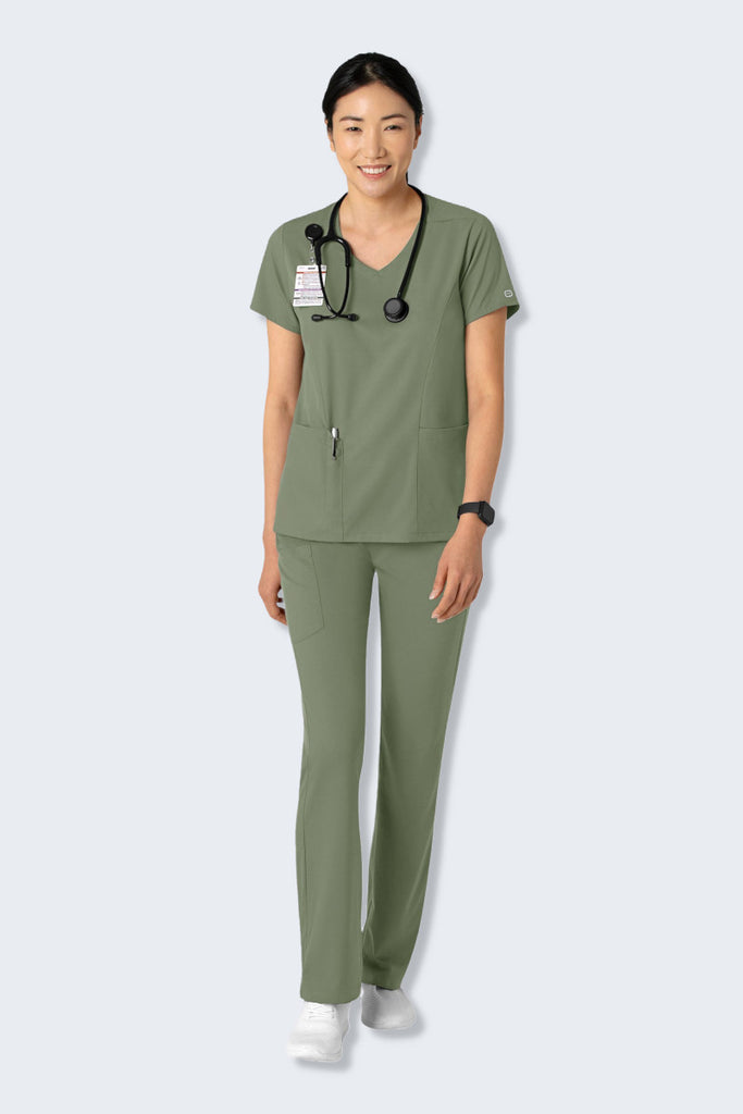 A female Doctor wearing the WonderWink Boundless 6251 V-neck Scrub Top and matching trousers in Sage Green. The top features a classic neckline, curved hem, and practical top-loading pockets, while the trousers offer a comfortable, modern fit. Both pieces are made from soft, stretchy, and sustainable fabric, ideal for healthcare professionals. Supplied by Infectious Clothing Co.