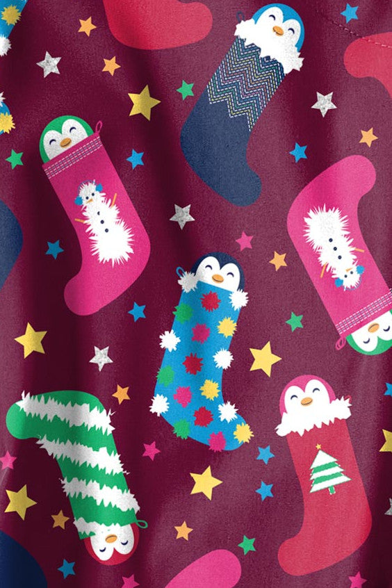 Close-up of a festive Christmas scrub print featuring colourful stockings filled with penguins, snowmen, and Christmas trees, set against a maroon background with star accents. Available at Infectious Clothing Co. in Australia